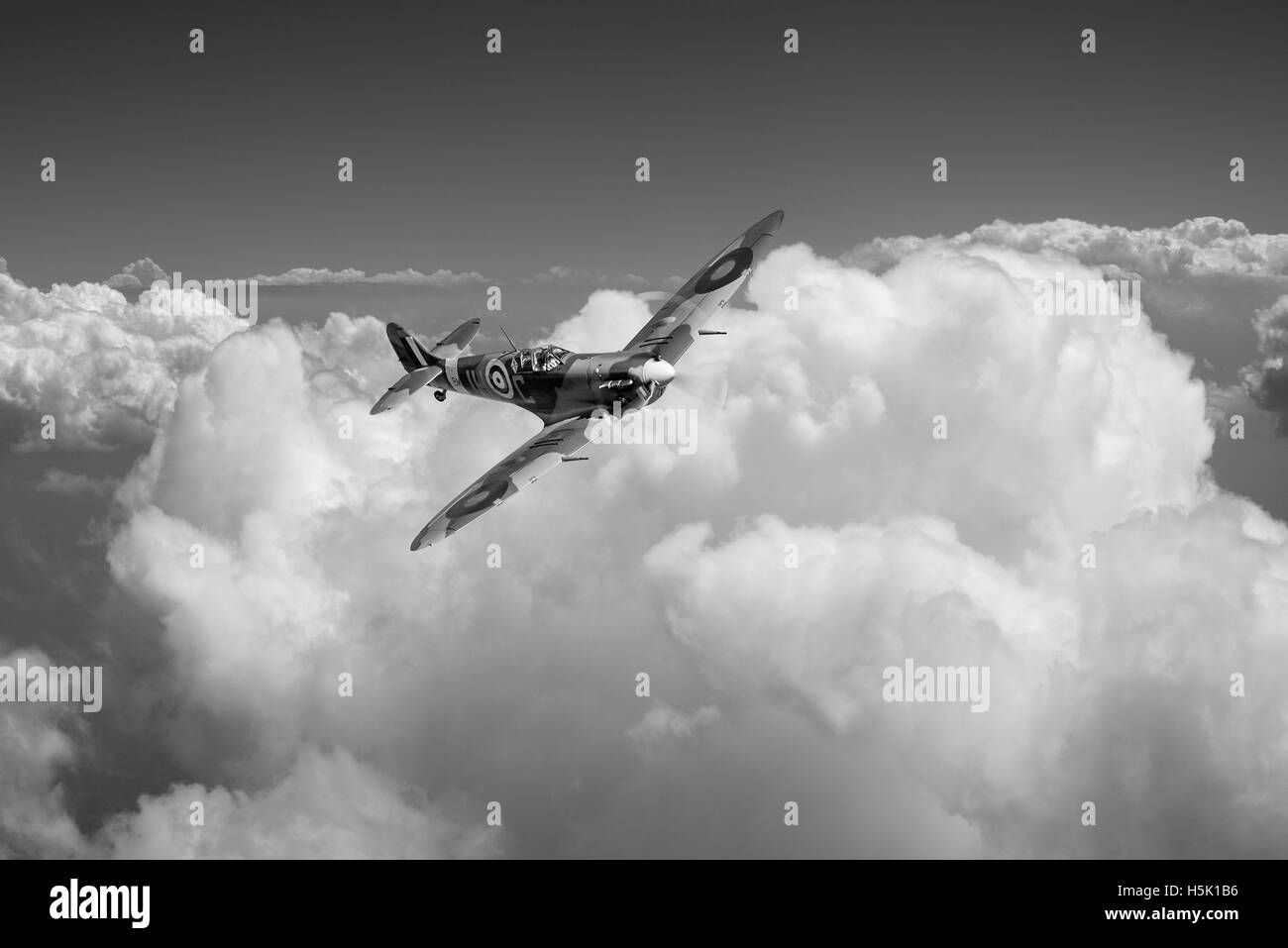 A depiction of Spitfire Vb in the colours of JH-C of 317 (Polish) Squadron RAF in bright sunshine above billowing clouds. Stock Photo