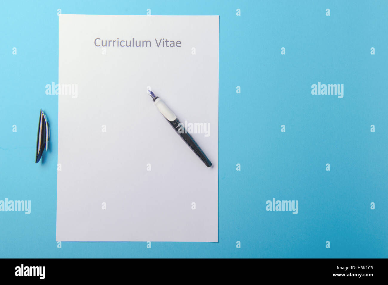 Curriculum Vitae Written On An Blank White Paper On Blue Background