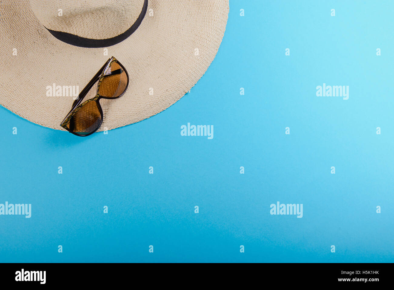 Straw hat and sunglasses on blue background. beach equipment Stock ...