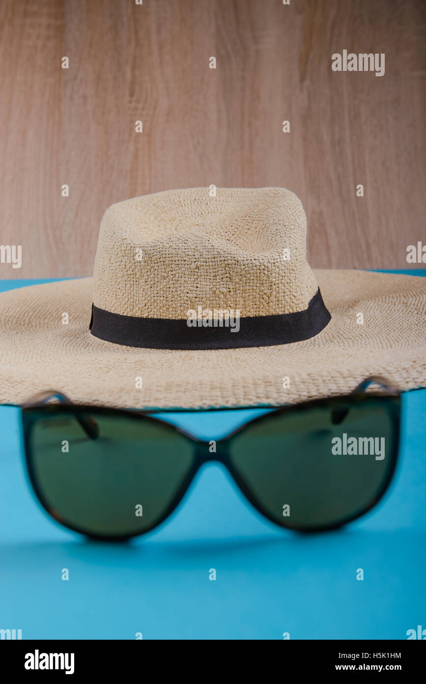 Straw hat and sunglasses on blue background. beach equipment Stock ...