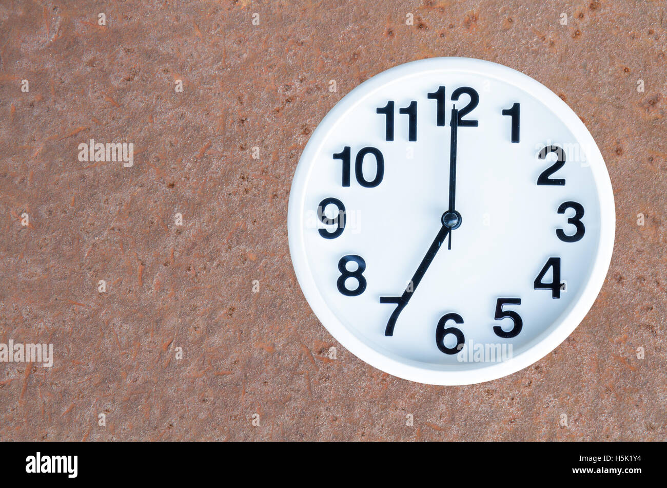 Clock show 7 am or pm on steel rusty background with copy space. clipping path in picture. Stock Photo