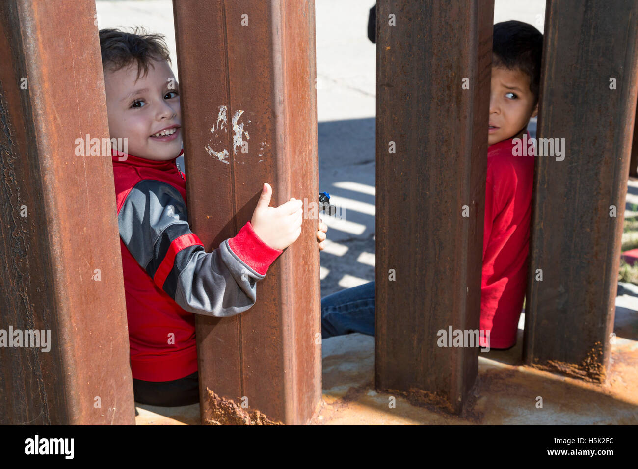 Nogales, Sonora Mexico - Boys on the U.S. side of the U.S.-Mexico border fence, looking into Mexico. Stock Photo