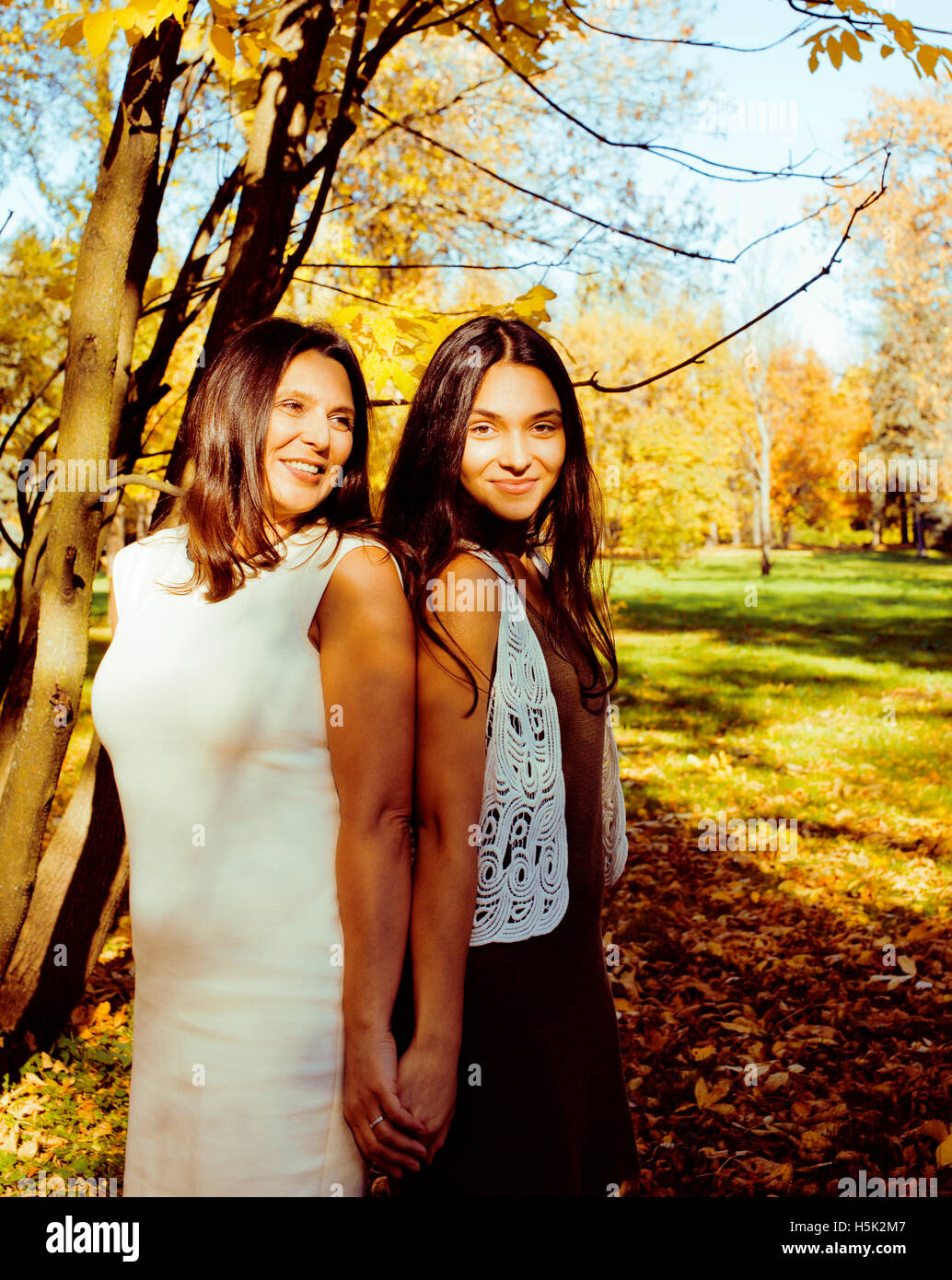 mature real mother with teenage daughter outside autumn fall in park