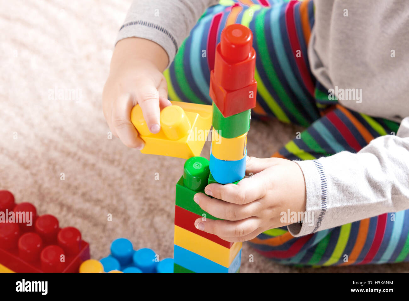Playing little boy with colored cubes Stock Photo