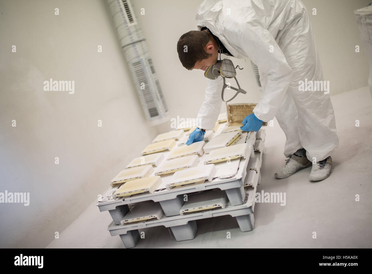 Painter using airbrush to paint wearing protective clothing Stock Photo