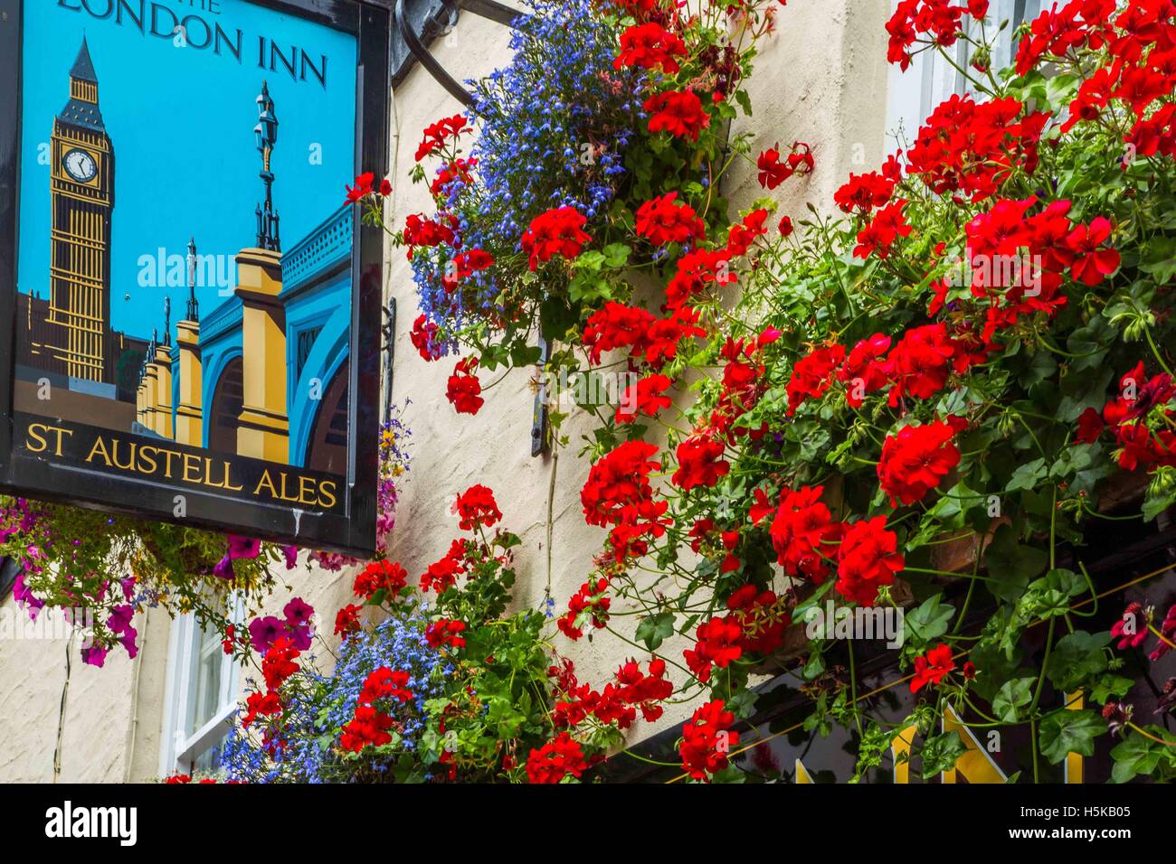 a pub sign in Padstow, Cornwall - The London Inn with white walls and red and blue hanging baskets outside Stock Photo