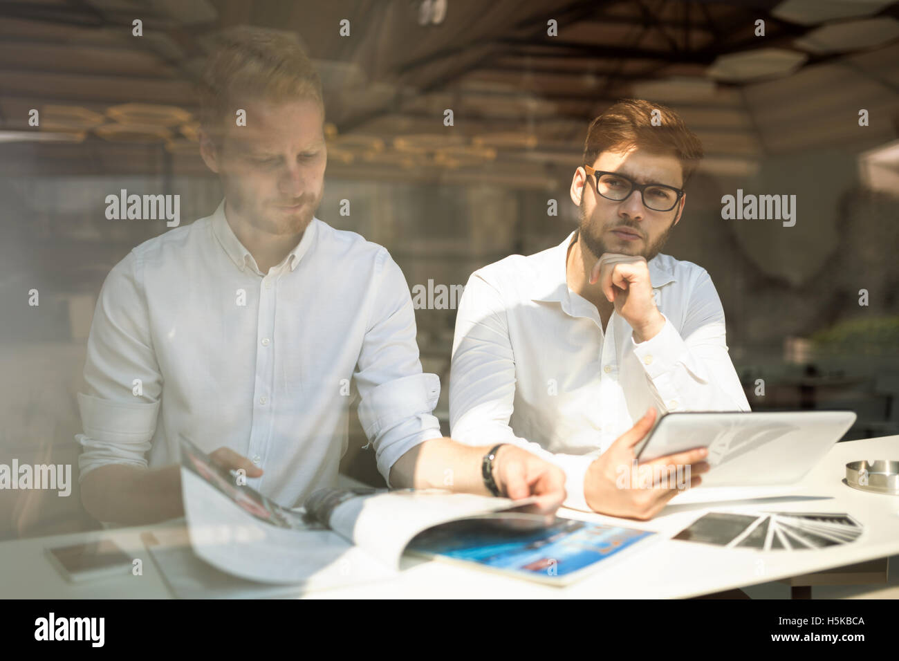 Colleagues reading newspaper together while on break Stock Photo