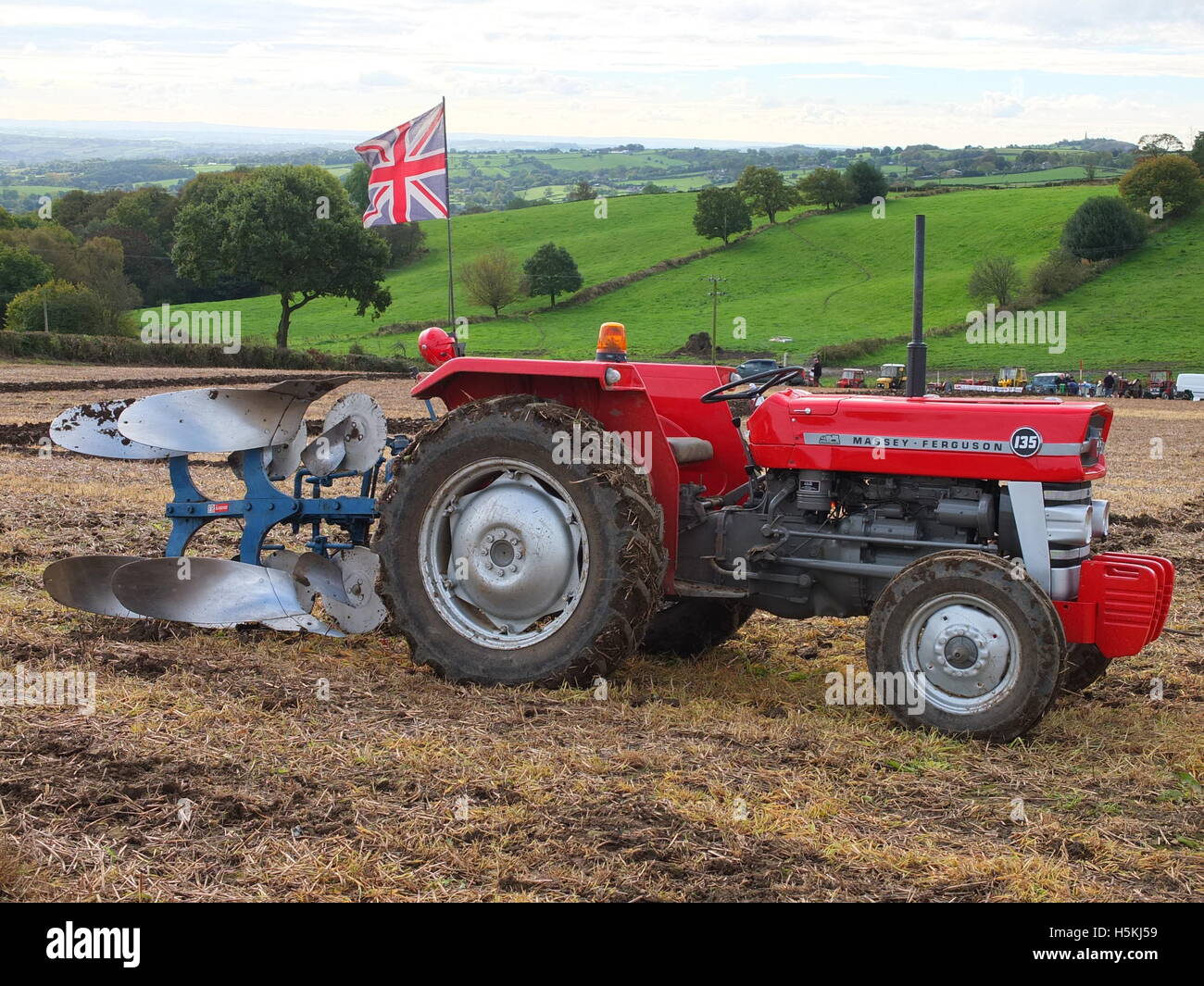 Tractor flying Union Jack flag on a farm with rolling Derbyshire countryside behind. Ashover