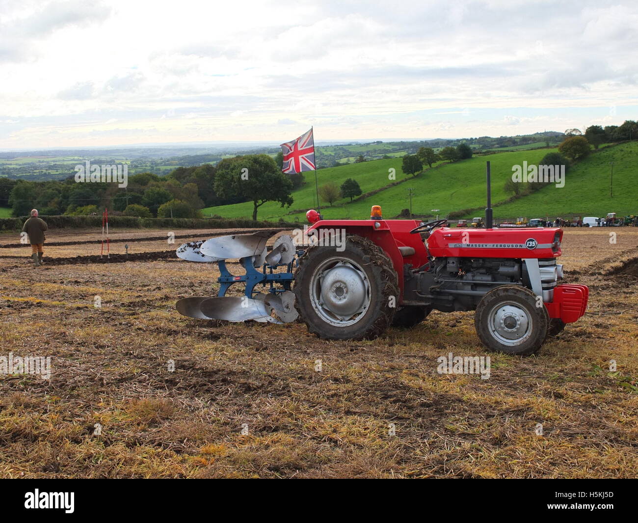 Tractor flying Union Jack flag on a farm with rolling Derbyshire countryside behind. Ashover