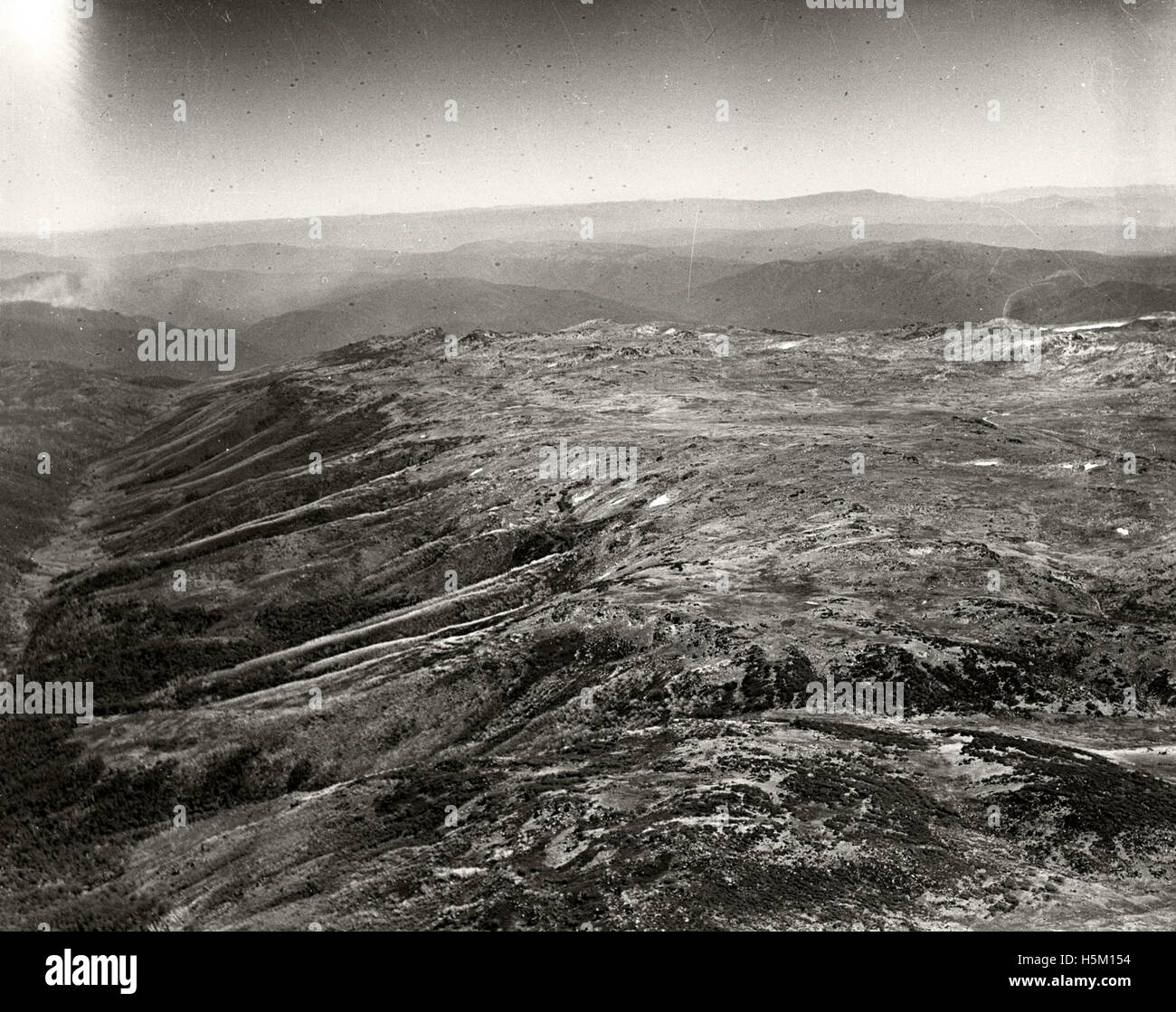 This aerial photograph captures the summit of Mount Kosciusko on 11 March 1937. The image is part of the Adastra Aerial Survey Collection and offers a historical view of the landscape in this region of Australia, showcasing the natural features of the iconic peak. Stock Photo