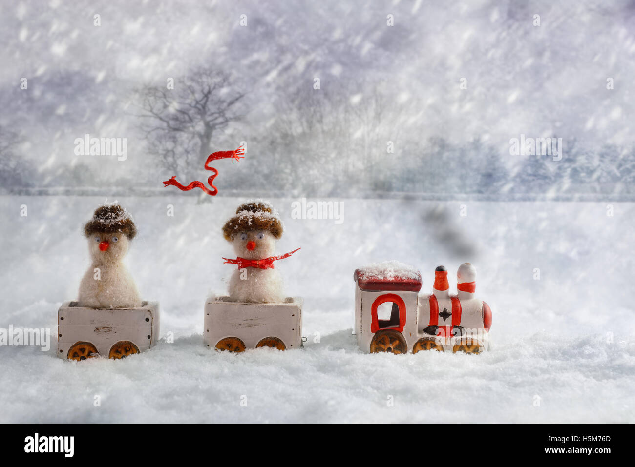 Christmas train set carrying snowmen, one with flying knitted scarf Stock Photo