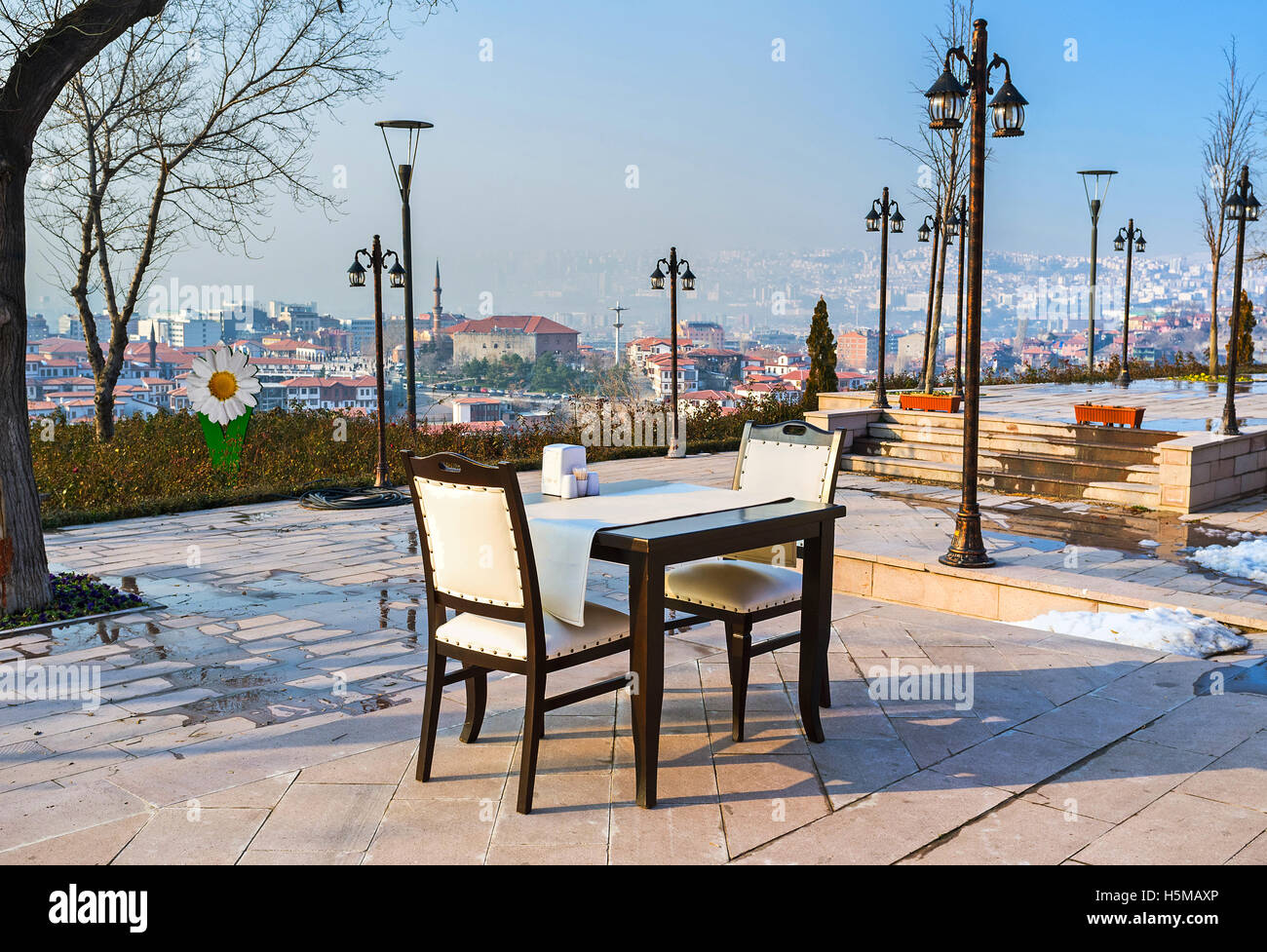 The outdoor restaurant on the Castle Hill overlooks the lower town with the Haci Bayram Mosque on adjacent hill, Ankara, Turkey. Stock Photo