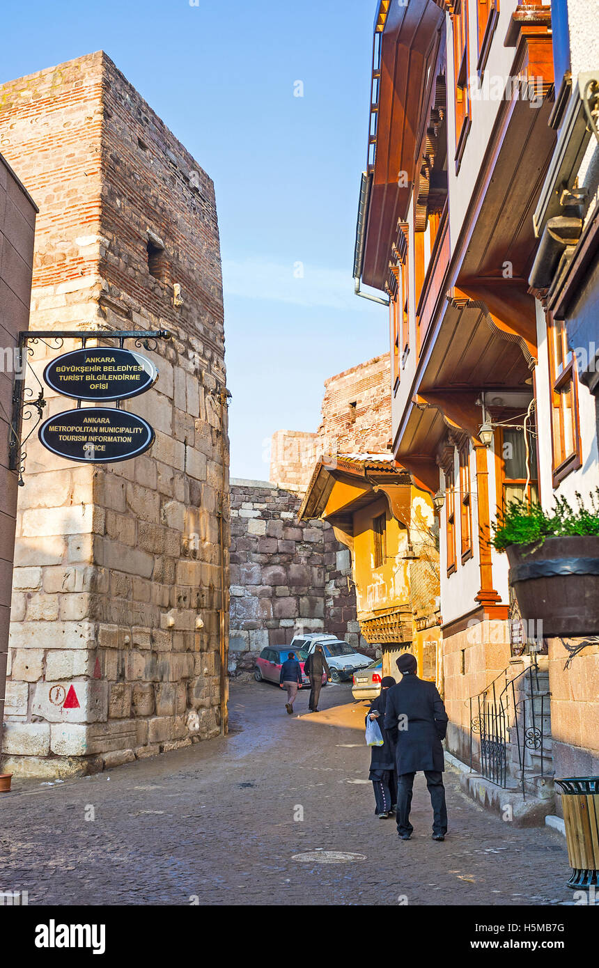 The narrow tourist street of the Turkish village with the tiny stalls and cozy cafes adjacent to the medieval fortress ramparts Stock Photo