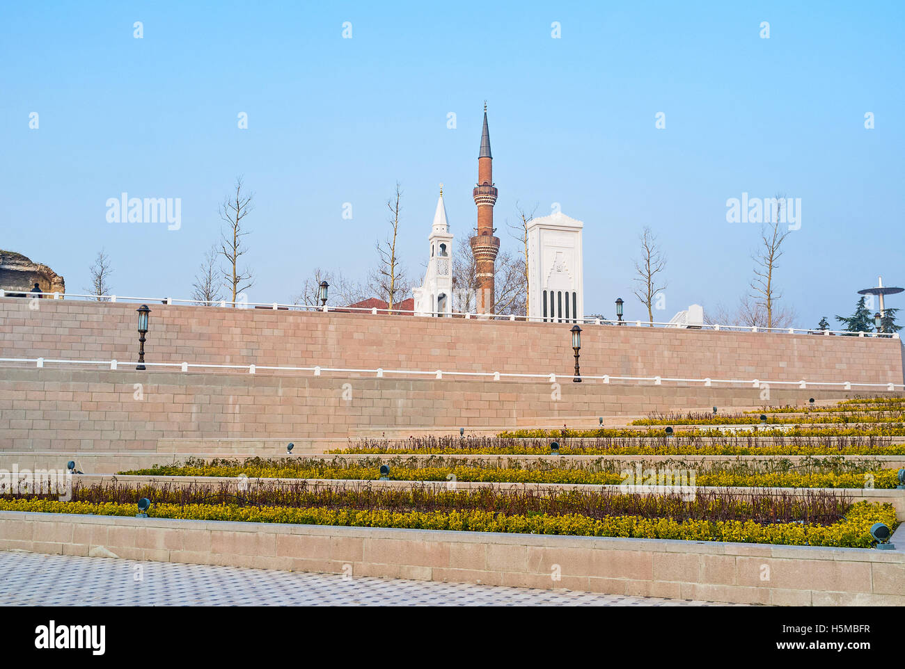 The scenic flower beds with the stone mihrab, minbar and the minaret of Haci Bayram Mosque on the background, Ankara, Turkey. Stock Photo