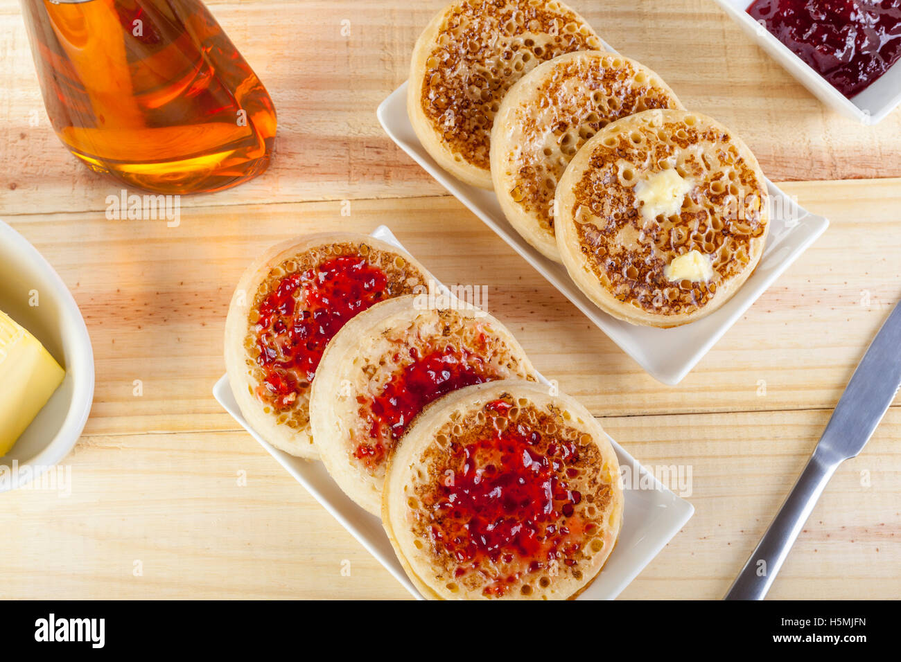 Freshly toasted crumpets on rectangular serving dishes with butter and