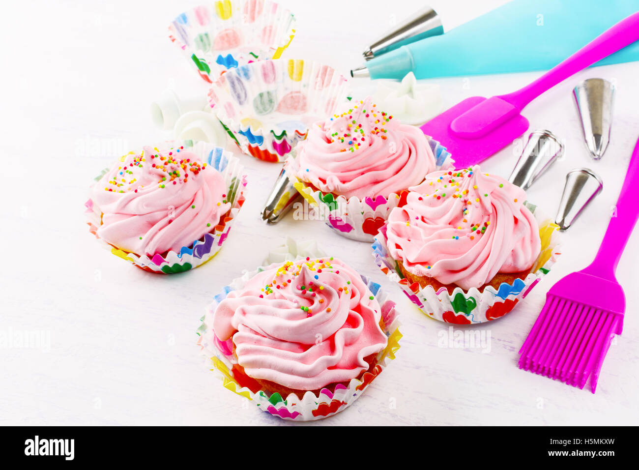 Swirl cupcake with whipped cream frosting and confectionery syringe