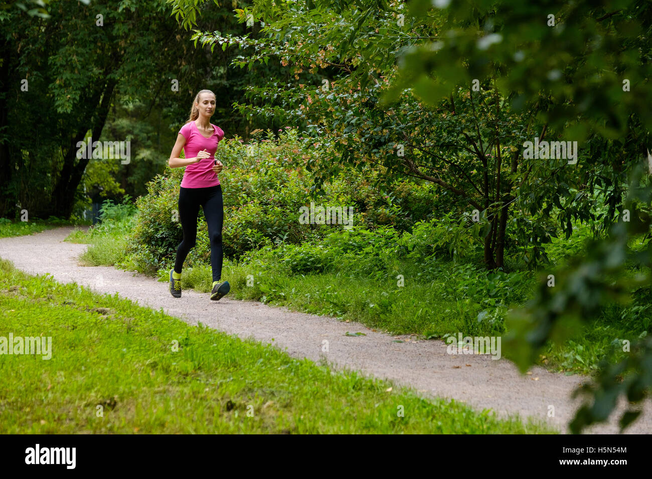 Young woman jogging in the park Stock Photo Alamy