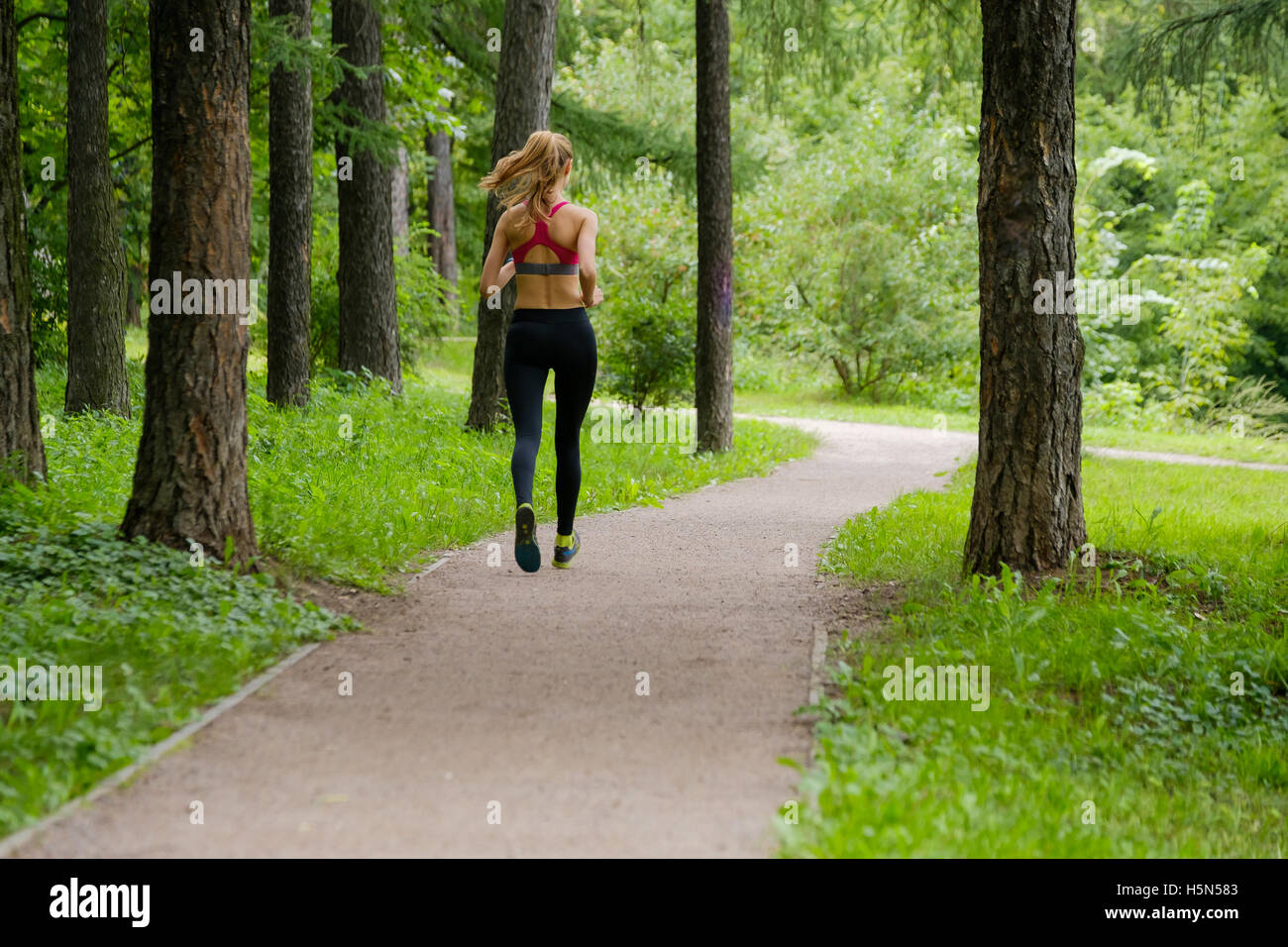Young woman jogging in the park Stock Photo - Alamy