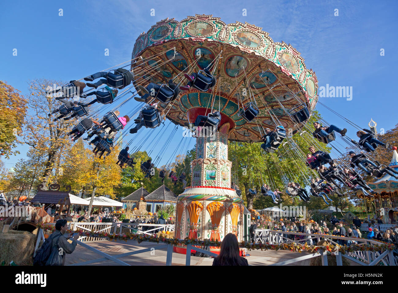 Halloween theme in the crowded Tivoli Gardens, Copenhagen, Denmark. The swing carousel or chairoplane ride on sunny afternoon in late October. Tivoli. Stock Photo