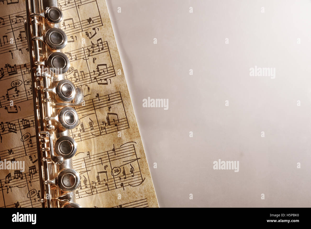 Flute and handwritten sheet music on white table. Horizontal composition. Top view Stock Photo