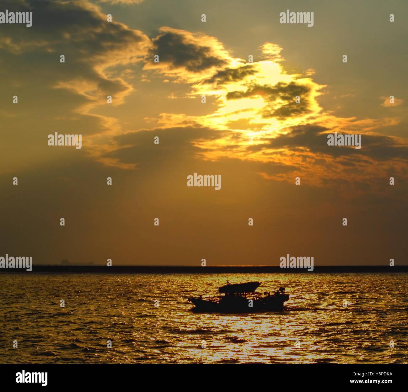 Silhouette of a fishing boat that returns to the harbor at sunset Stock ...
