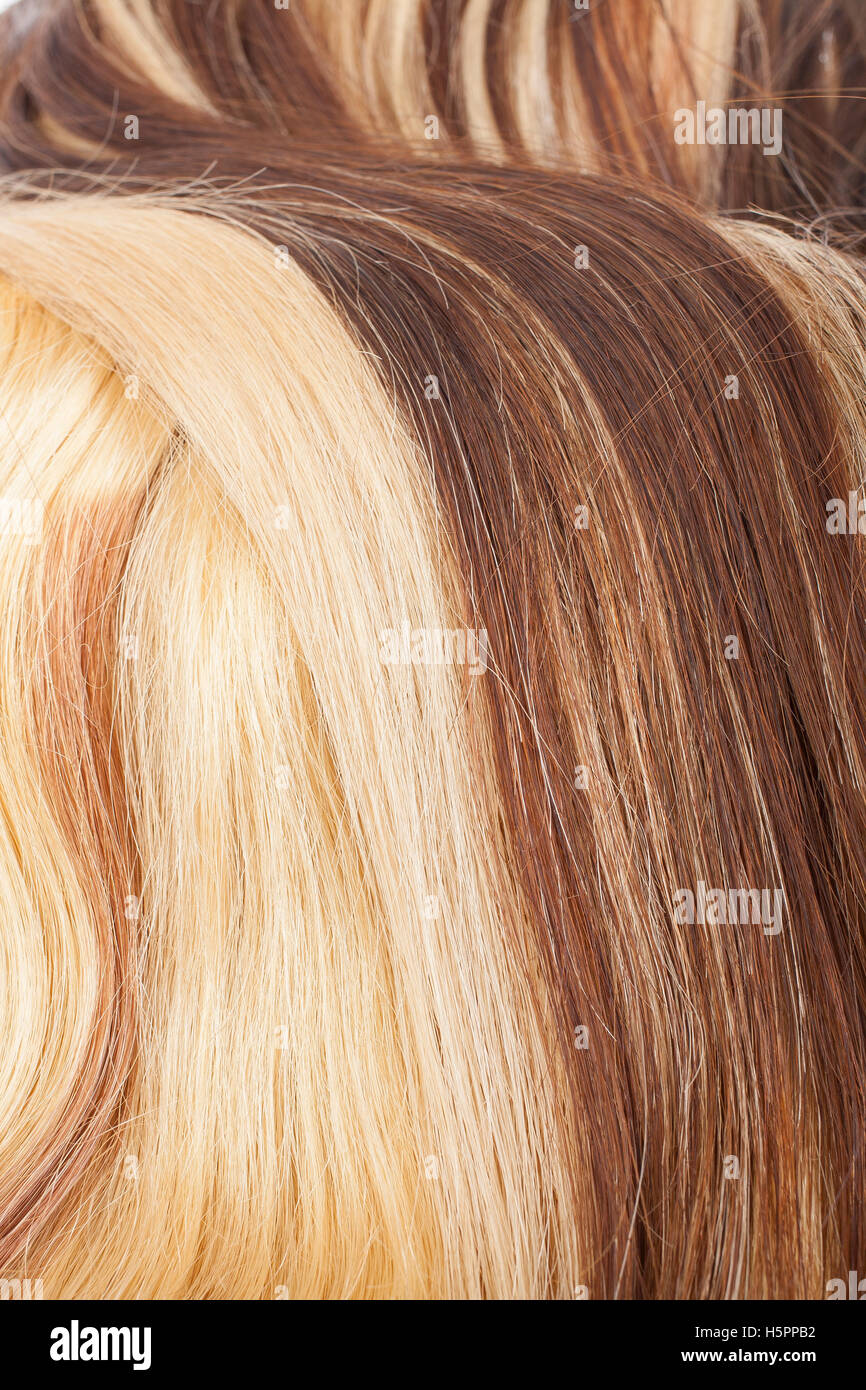Blond red and black real women human hair extension weft close up photo. Real European healthy long hear. Stock Photo