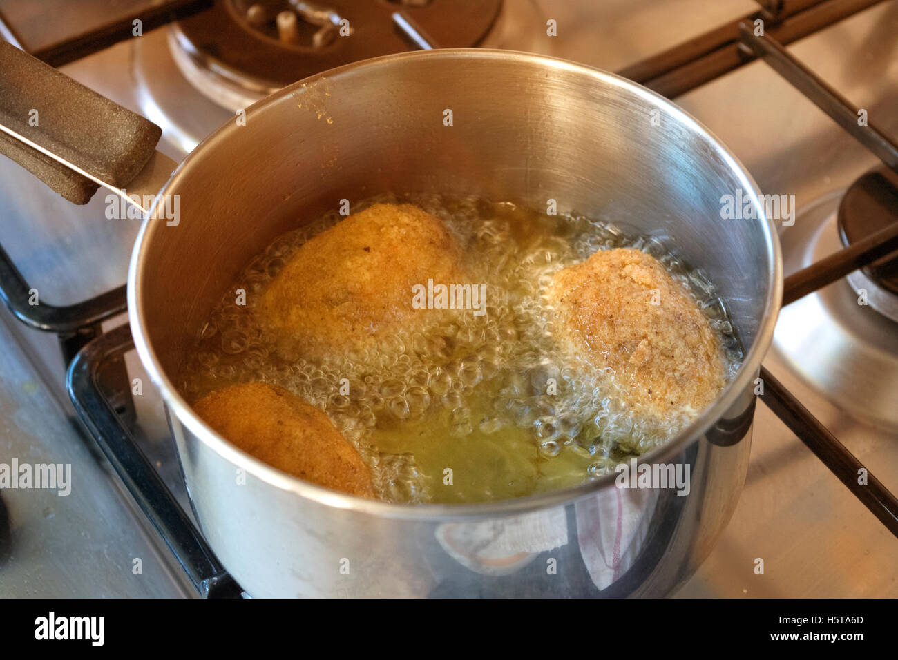 rice balls frying in pan in olive oil Stock Photo