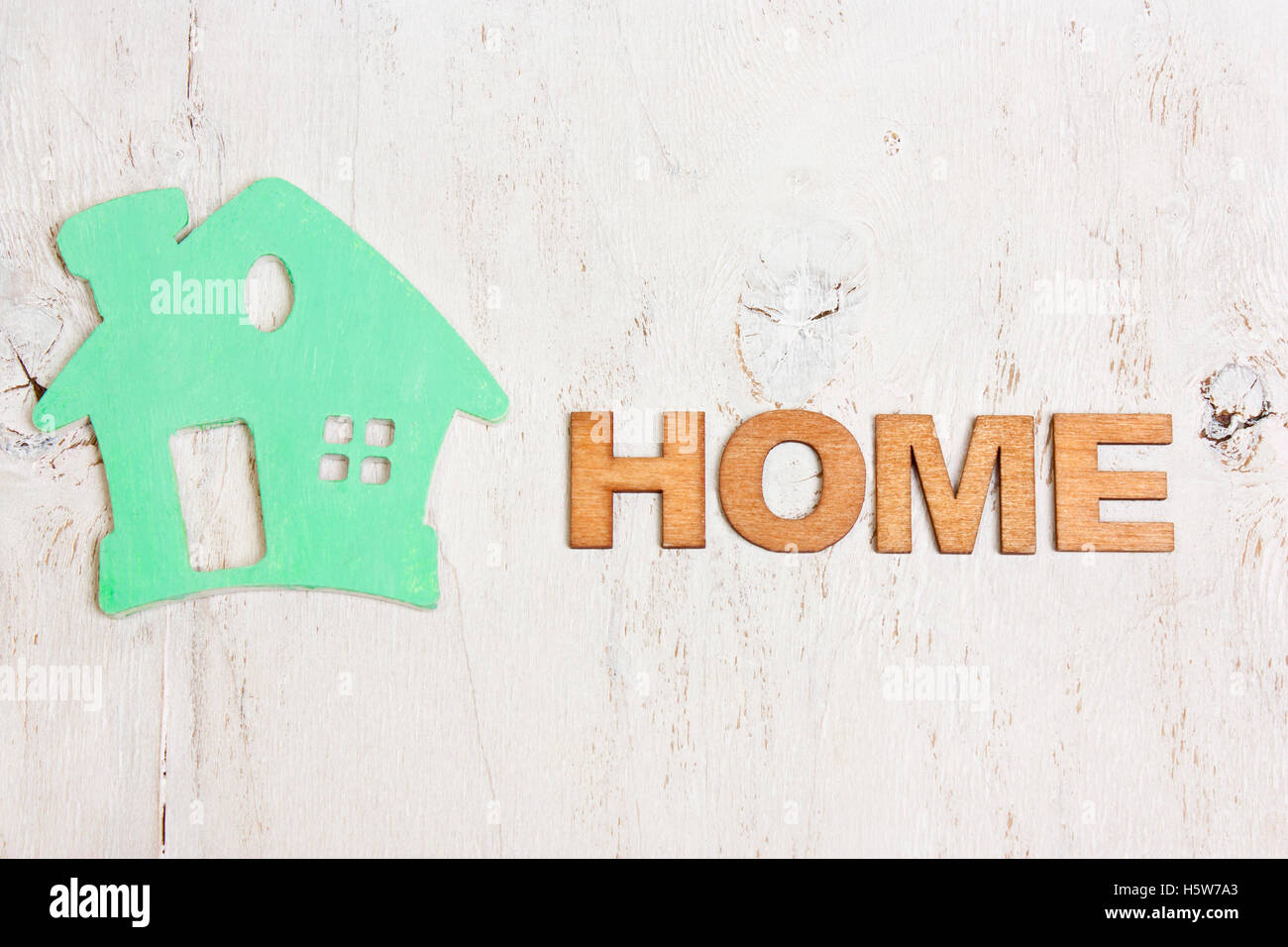 word home made of wooden letters and a green house on a white background old wooden Stock Photo