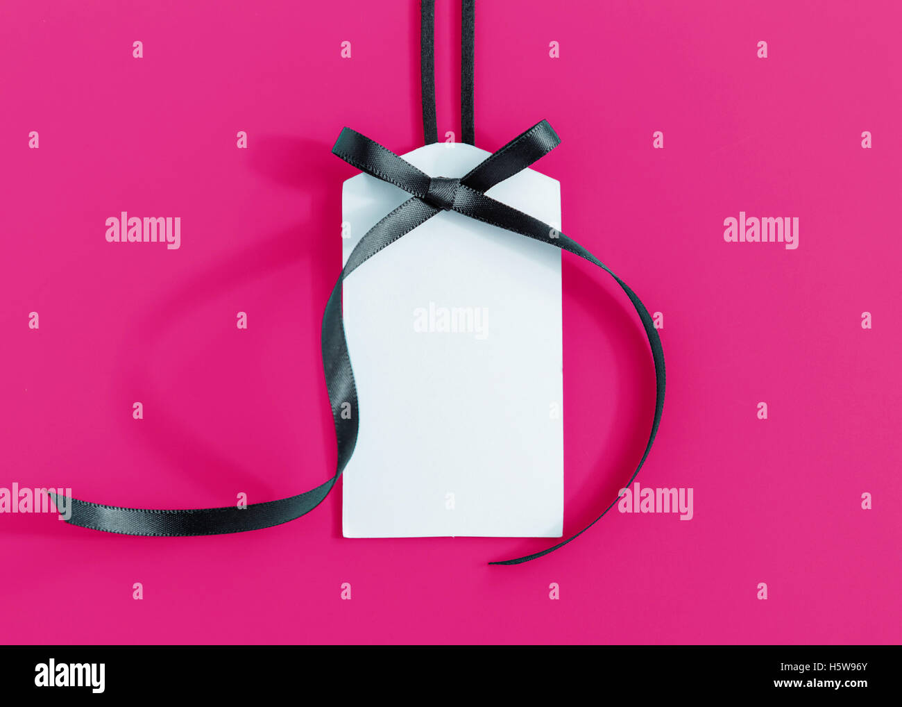 Gift tag with ribbon on pink background Stock Photo - Alamy