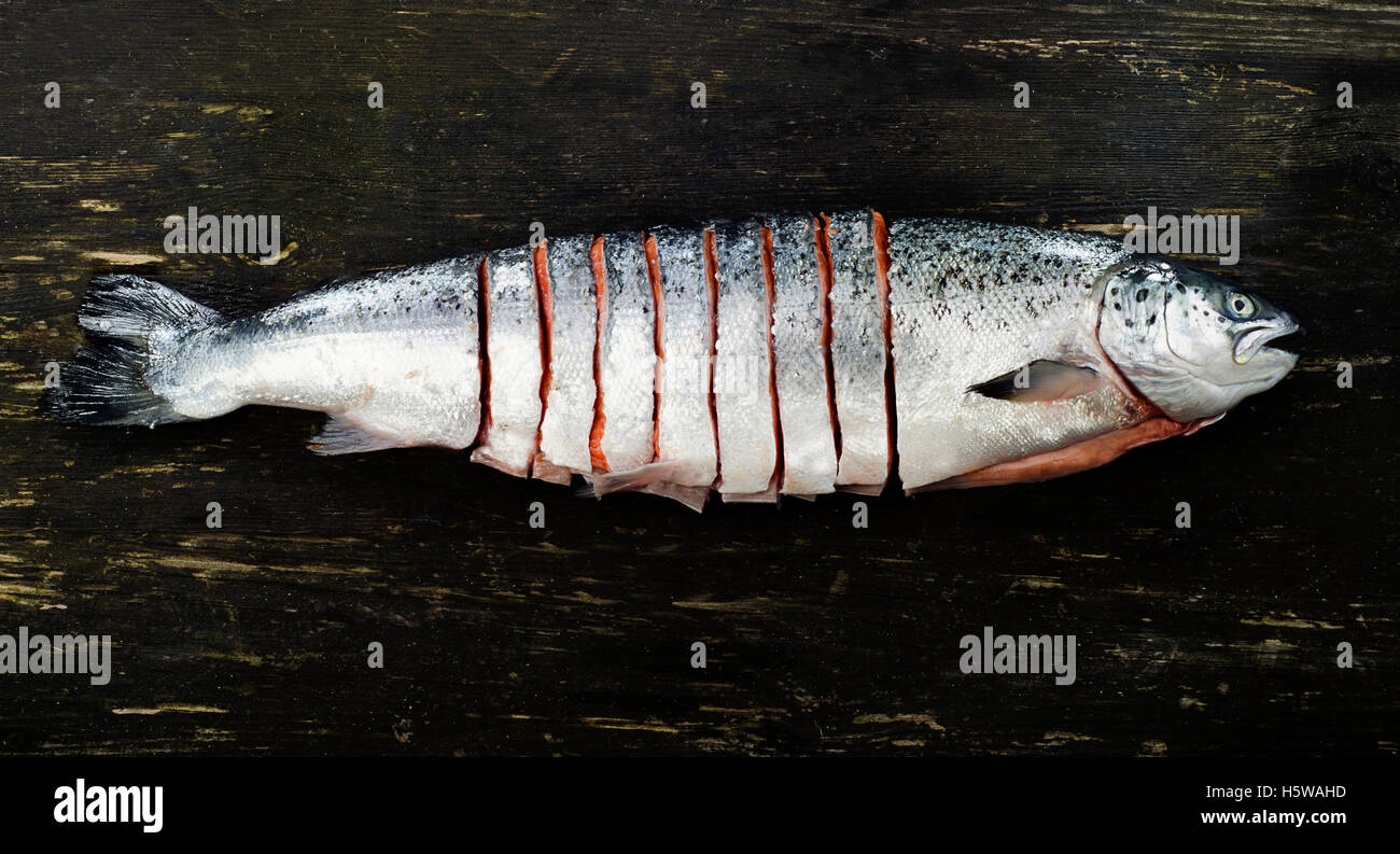 Raw salmon on dark rustic table. Top view. Fish preparing for cooking. Healthy food  concept. Stock Photo