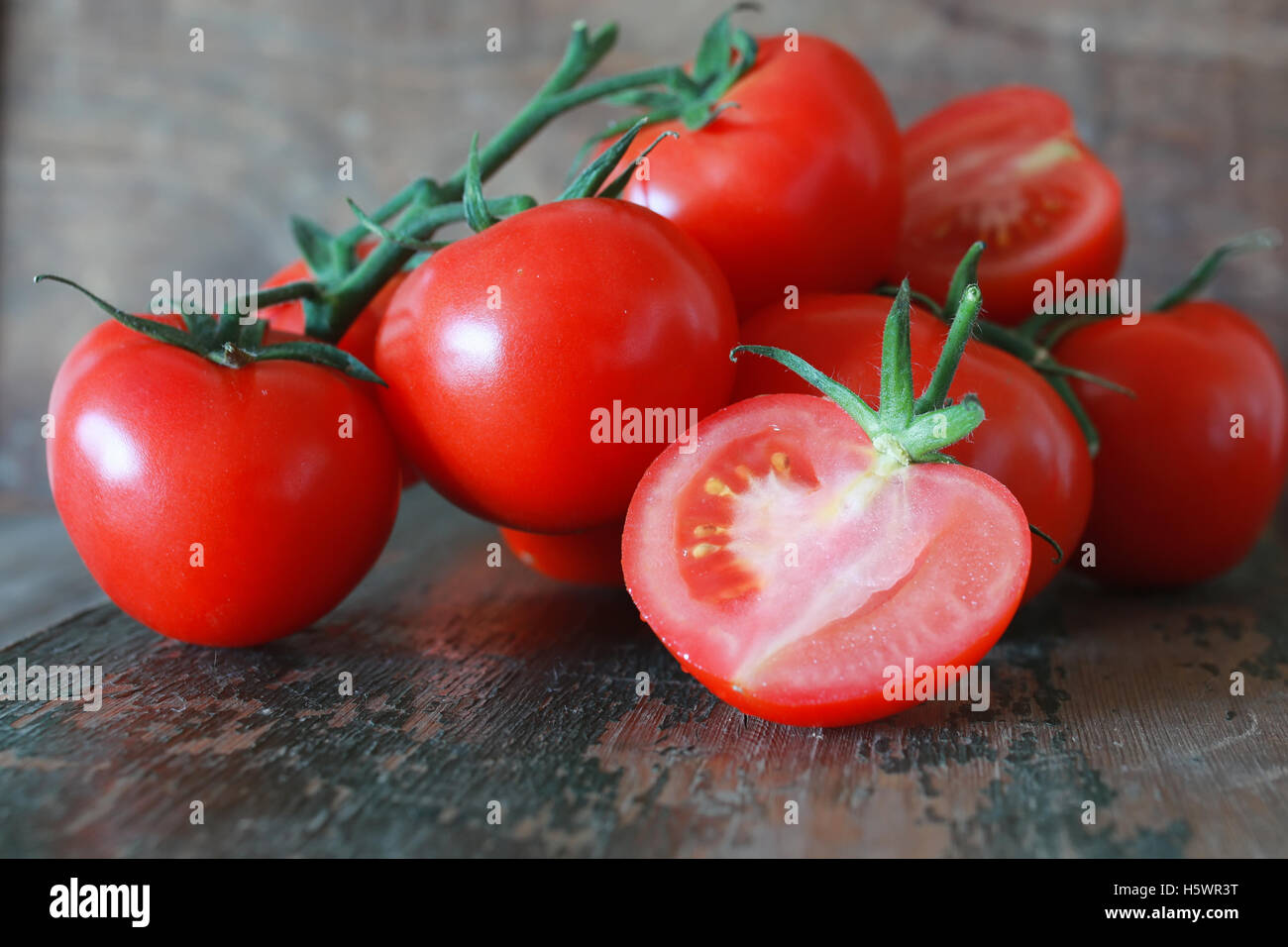 branch of tomatoes on wooden background Stock Photo - Alamy