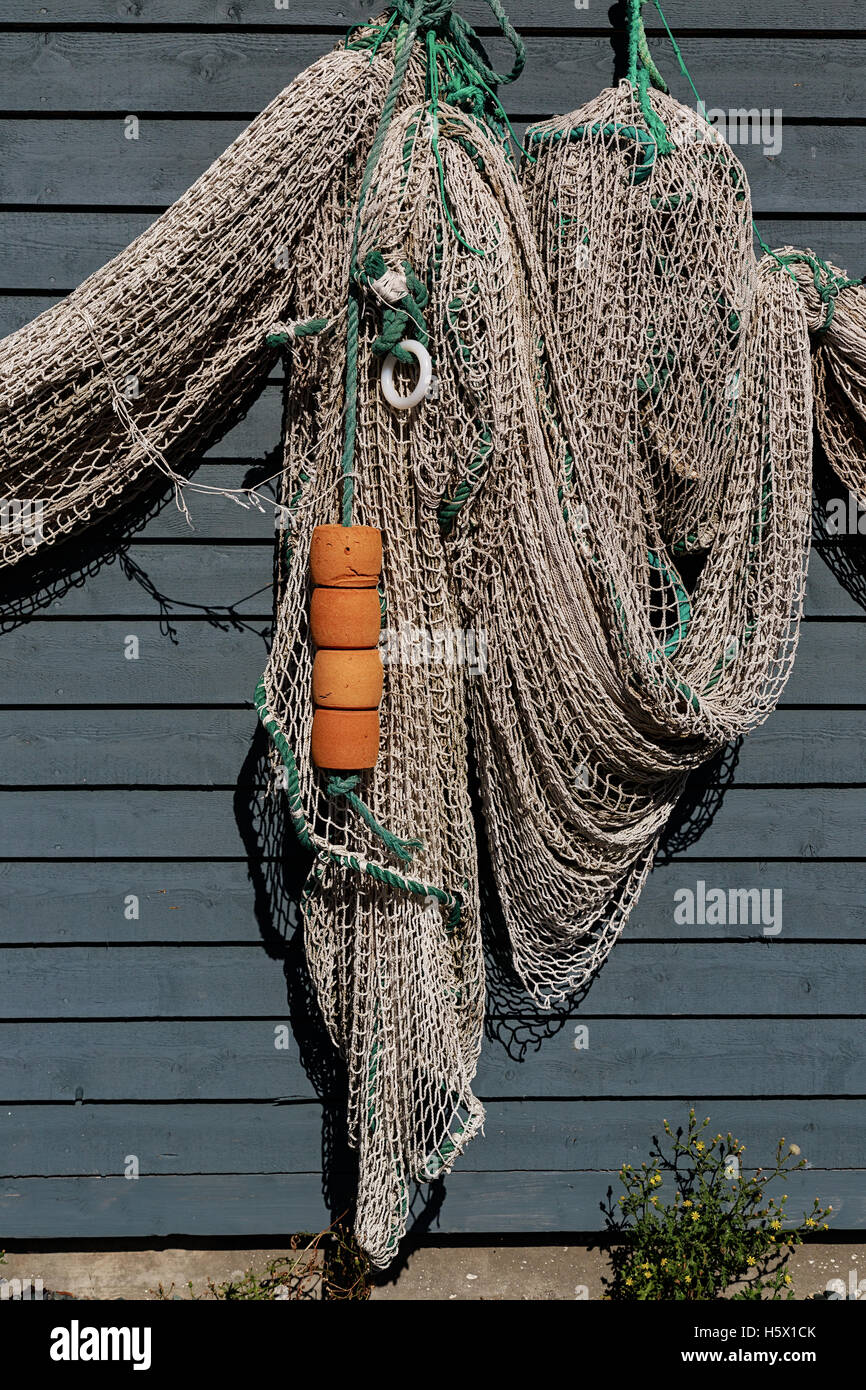 Newfoundland fish net and buoys hanging on a rustic wall. Stock Photo