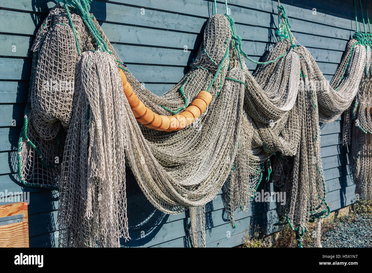 Newfoundland fish net and buoys hanging on a rustic wall. Stock Photo