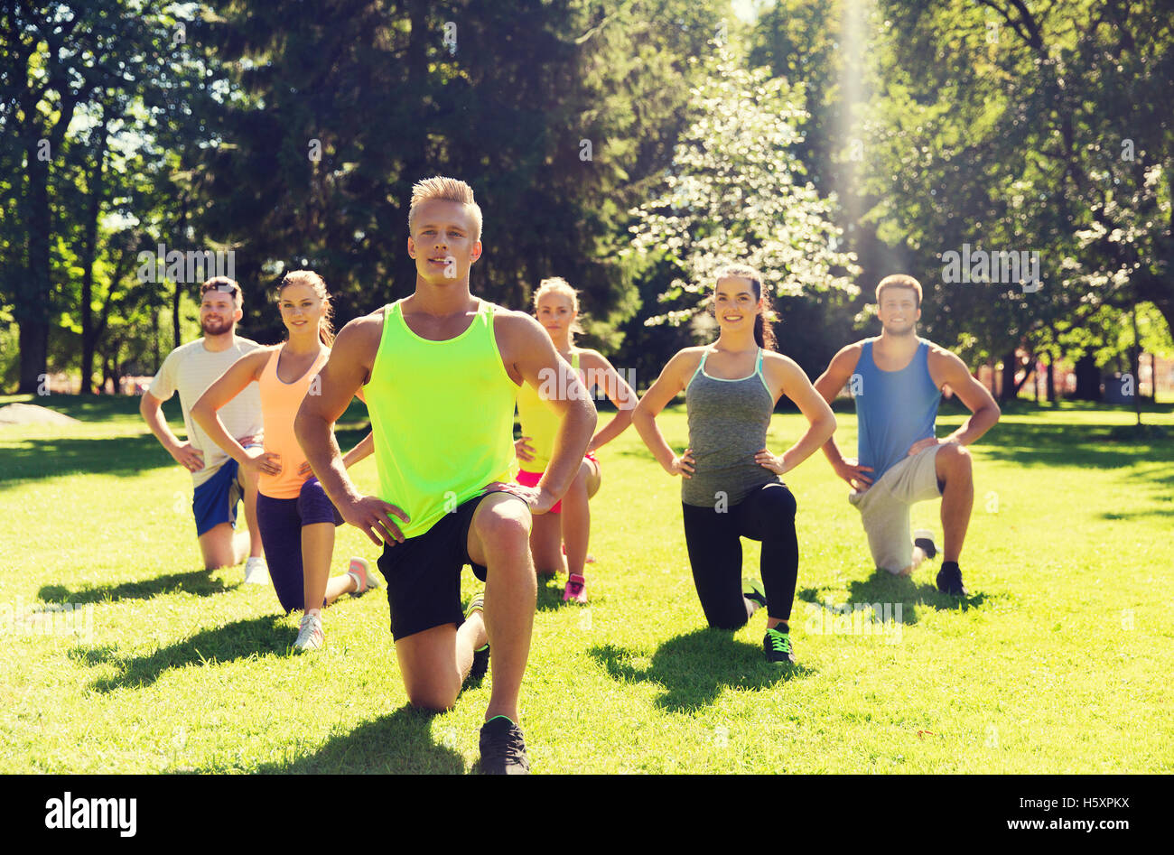 group of friends or sportsmen exercising outdoors Stock Photo - Alamy