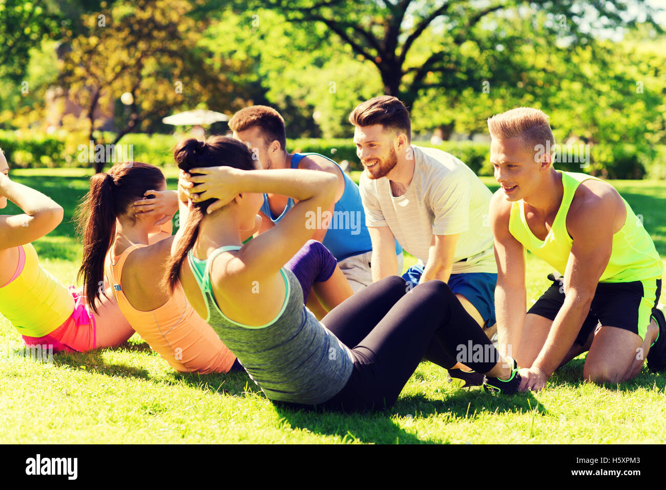 group of friends or sportsmen exercising outdoors Stock Photo