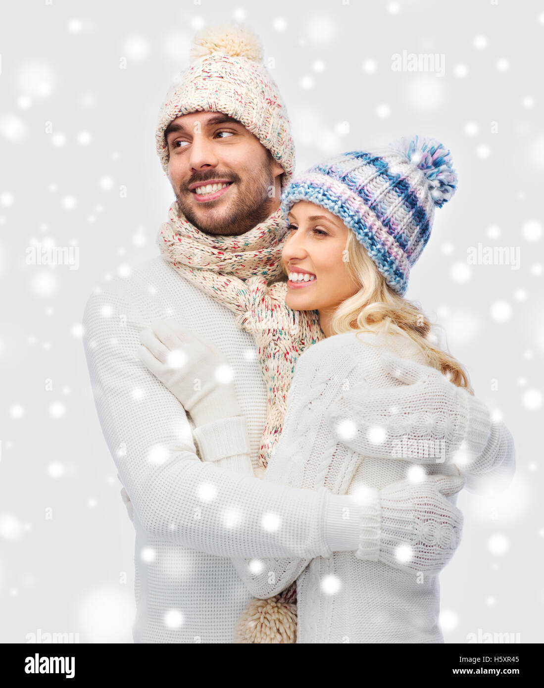 smiling couple in winter clothes hugging Stock Photo - Alamy