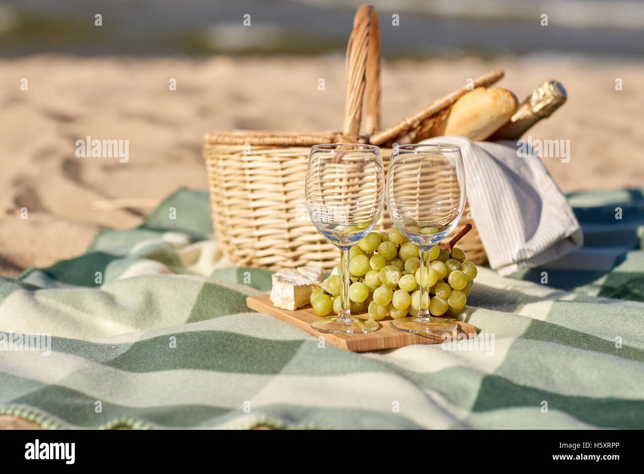 picnic basket with wine glasses and food on beach Stock Photo Alamy