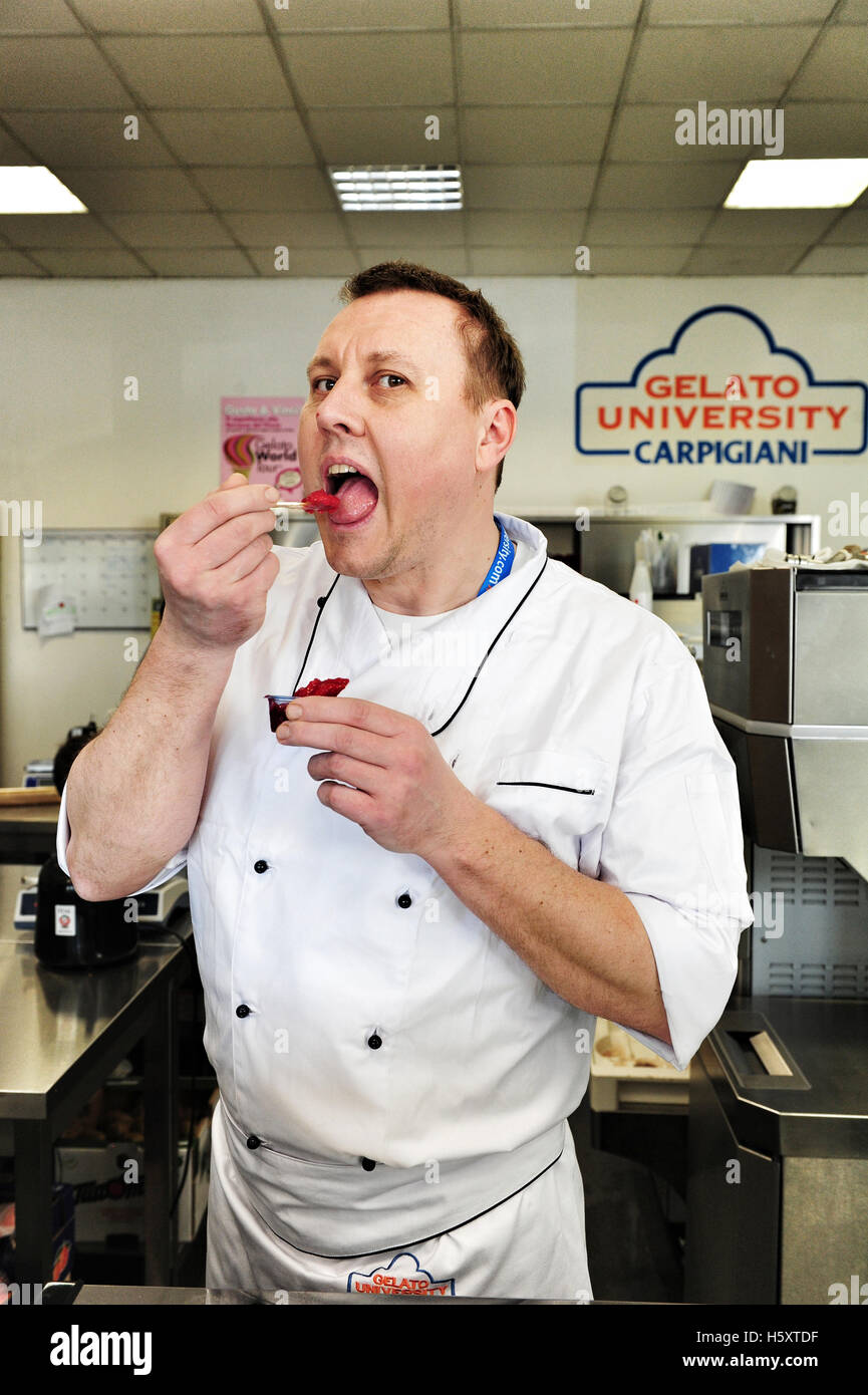 A student gets to taste the sorbet he has just prepared at the end of a practical lesson at the Carpigiani Gelato University Stock Photo