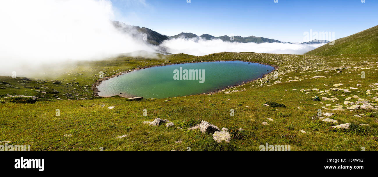 Panoramic view of a glacial lake on top of the foggy Kackar mountains in a sunny day Stock Photo