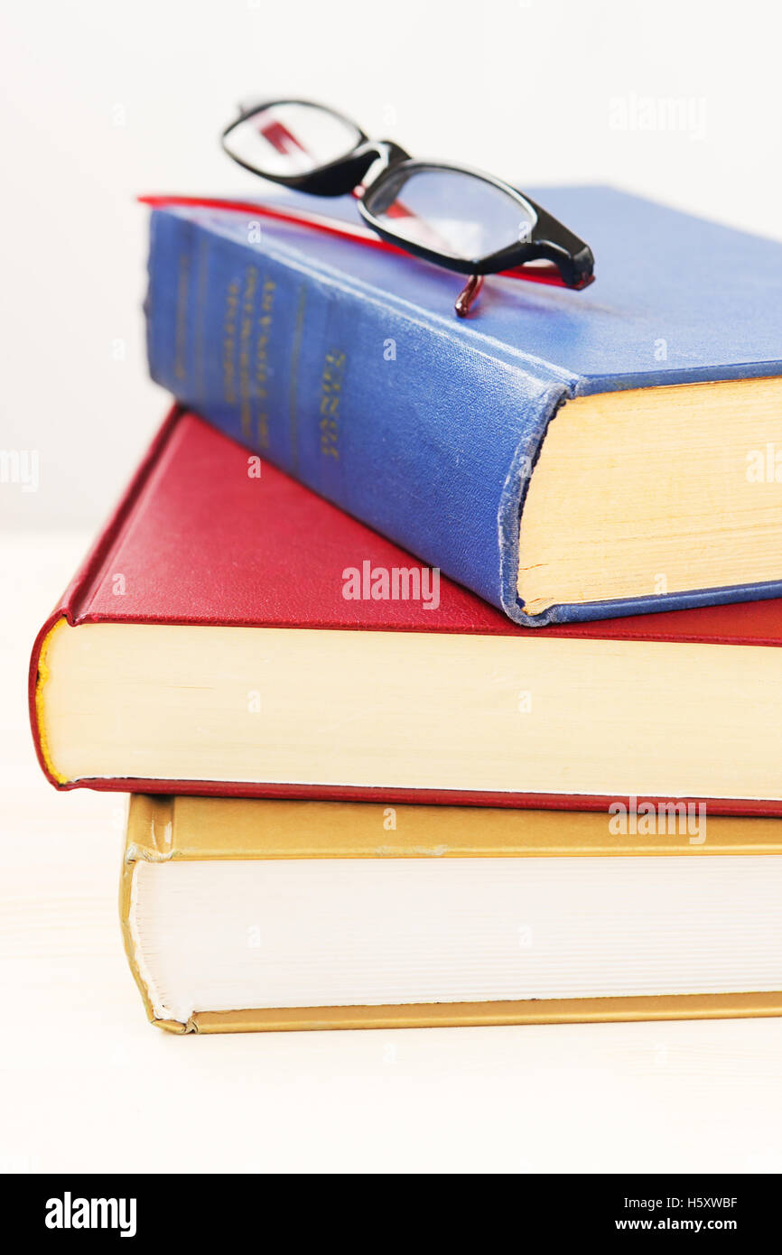 Eyeglasses on the three thick books Stock Photo