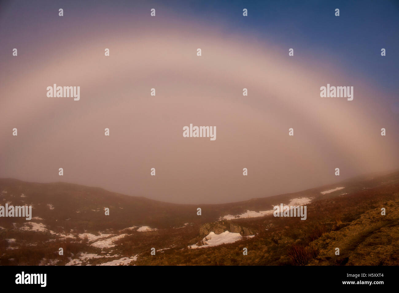 The mountain phenomenon of a fogbow appears near Heron Pike on the Fairfield Horseshoe walk in the Lake District. Stock Photo