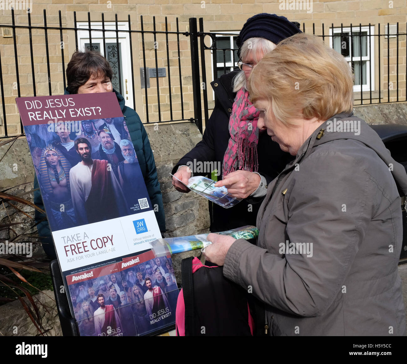 Two ladies from Jehovah's Witnesses show a woman their leaflets in Bakewell, Derbyshire.. Stock Photo