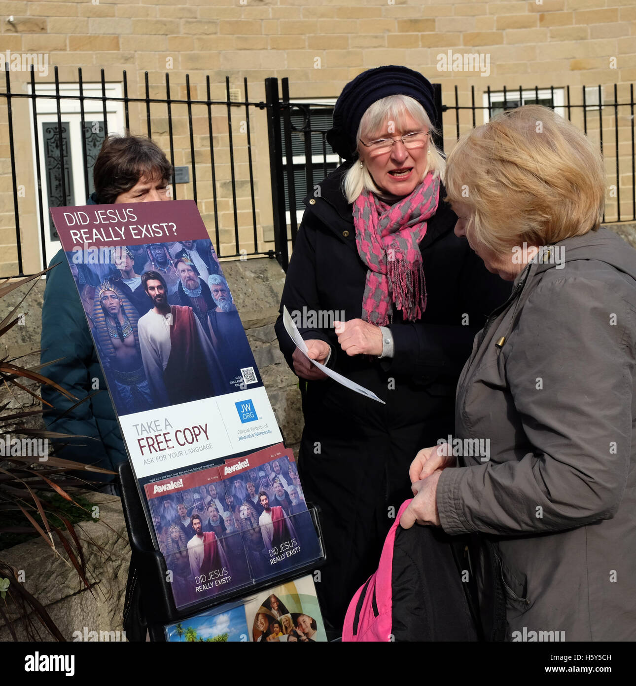 Two ladies from Jehovah's Witnesses talk to a woman about their faith in Bakewell, Derbyshire.; Stock Photo