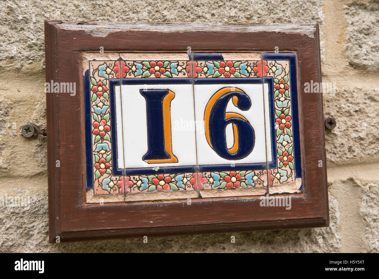 The number sixteen made with ceramic tiles on a plaque on a home to show the properties address Stock Photo