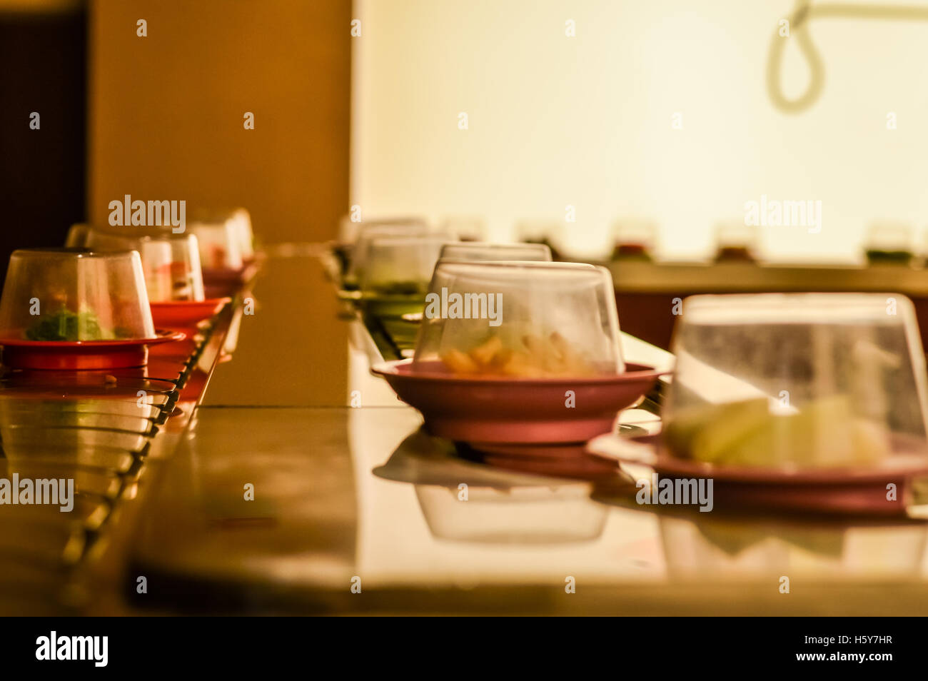 dishes on the conveyor belt sushi in a Kaiten Sushi Japanese Restaurant Stock Photo