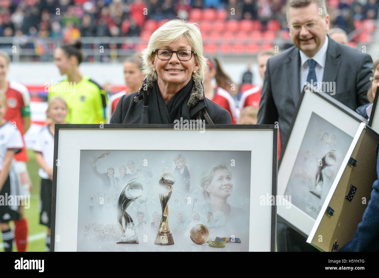 Regensburg, Germany. 22nd Oct, 2016. Germany's Women's National Soccer team coach Silvia Neid receiving her farewell after the Women's international soccer match between Germany and Austira at the Continental Arena in Regensburg, Germany, 22 October 2016. DFB President Reinhard Grindel can be seen behind her. PHOTO: ARMIN WEIGEL/dpa/Alamy Live News Stock Photo