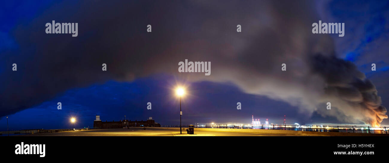 Large fire at Liverpool docks with the smoke plume passing over New Brighton and on towards North Wales early morning Stock Photo