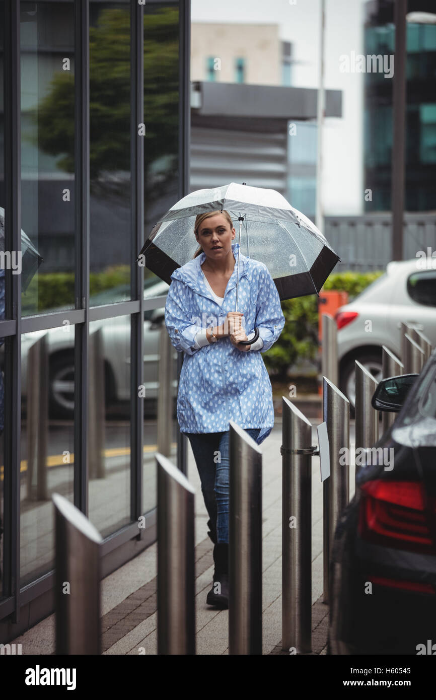 Beautiful woman holding umbrella and walking on walkway Stock Photo - Alamy