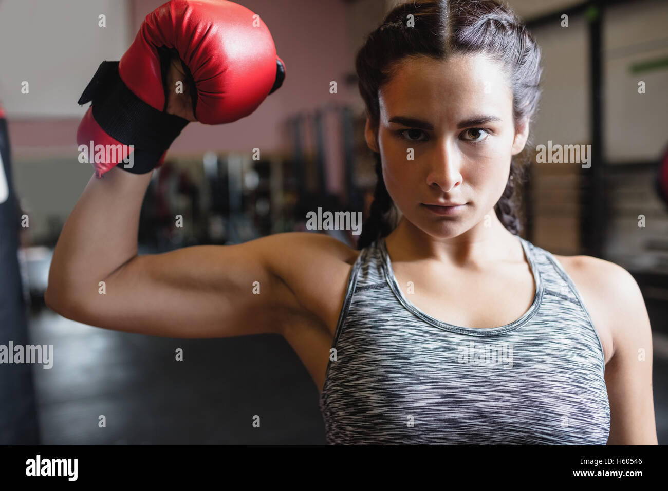 Portrait of female boxer in boxing gloves showing muscle Stock Photo