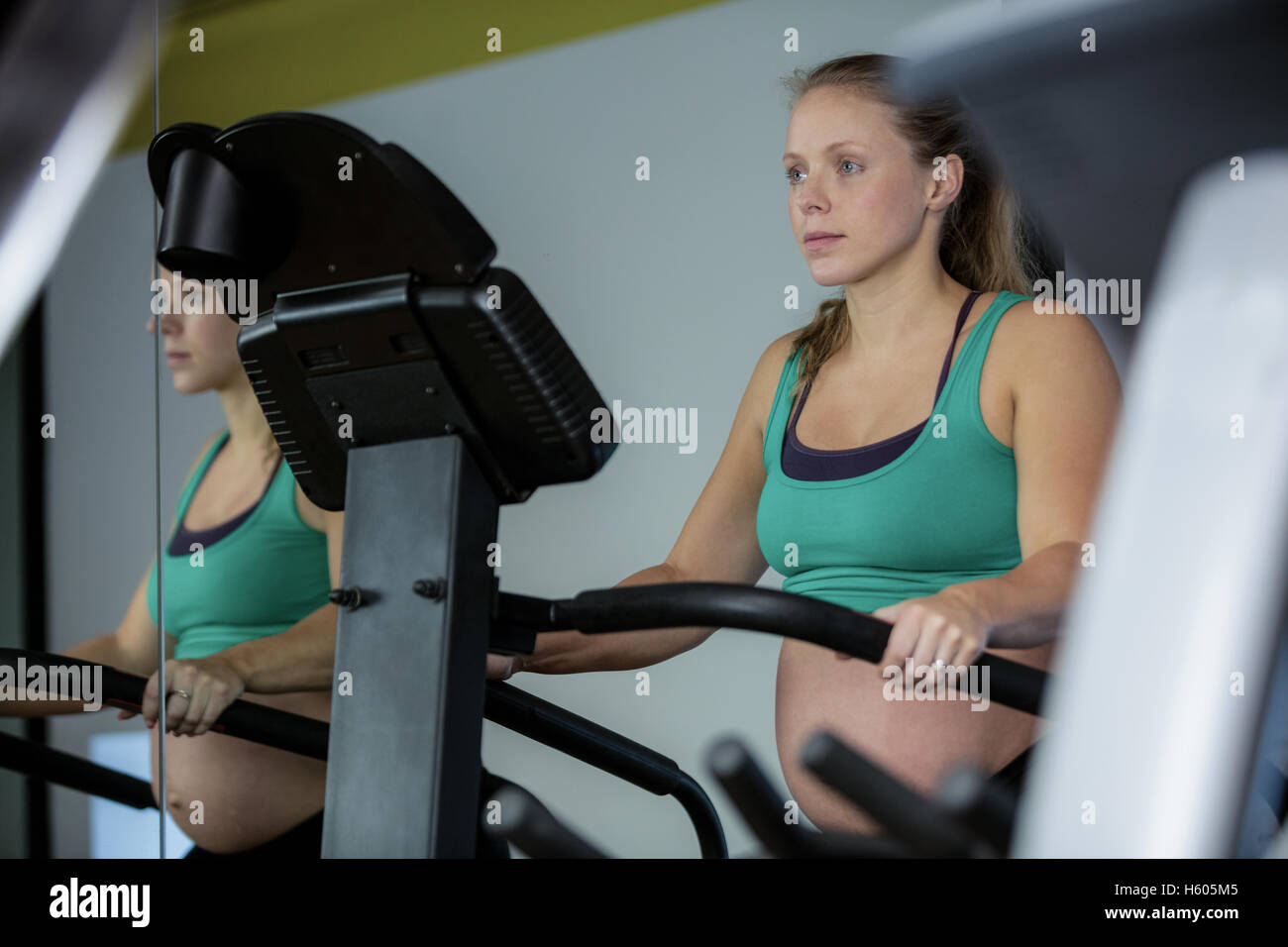 Pregnant woman exercising on elliptical machine Stock Photo Alamy